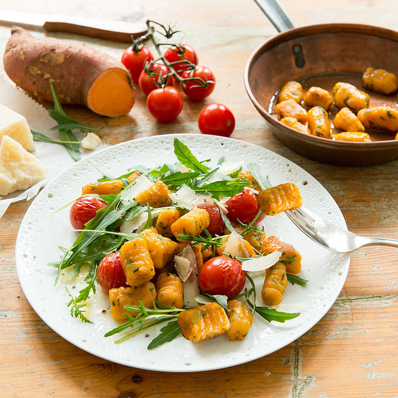 Gnocchis de patate douce avec roquette et tomates au four