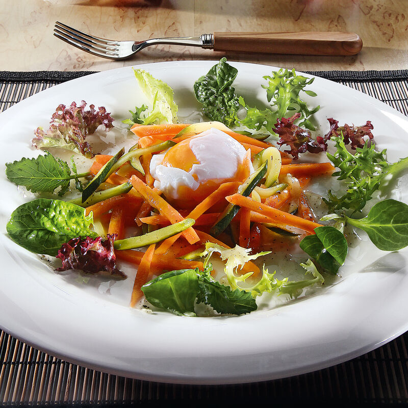 OEufs pochés avec une julienne de légumes sur  un lit de salade coloré