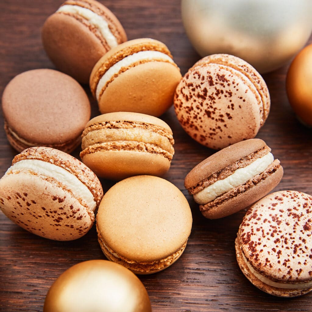 Bunte Auswahl an französischen Macarons mit Schokolade, Karamell und Vanille, festlich angerichtet